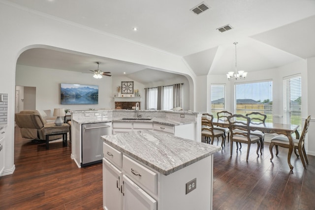 kitchen featuring stainless steel dishwasher, open floor plan, an island with sink, and a sink