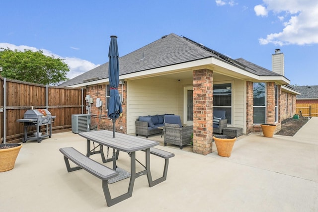 rear view of property featuring a patio, an outdoor living space, and roof with shingles