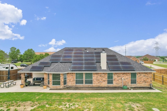 back of house featuring a patio, a fenced backyard, roof with shingles, and brick siding