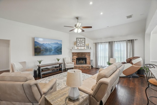 living room with visible vents, a ceiling fan, a brick fireplace, and dark wood-type flooring