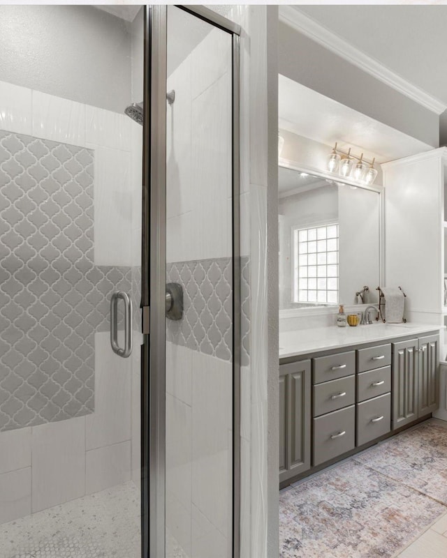full bathroom featuring vanity, ornamental molding, and a shower stall