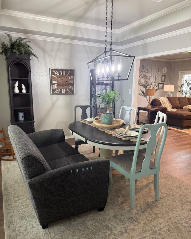 dining room featuring ornamental molding, wood finished floors, and a notable chandelier
