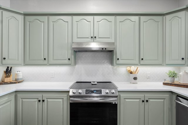 kitchen with light countertops, appliances with stainless steel finishes, decorative backsplash, and under cabinet range hood