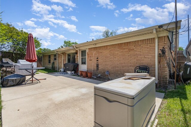 view of patio featuring an outdoor structure, a fenced backyard, and a storage unit