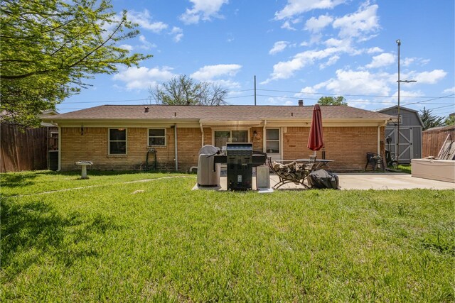 rear view of house with brick siding, central AC unit, fence, and a yard