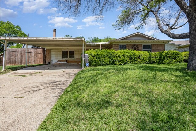 view of front of home featuring a front lawn, fence, and a carport