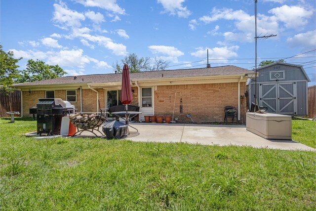 rear view of house featuring fence, brick siding, a patio area, a lawn, and a storage shed