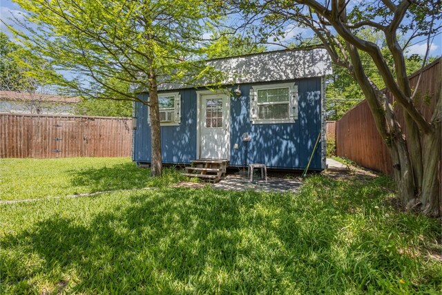 back of house featuring brick siding, a patio area, and a storage unit