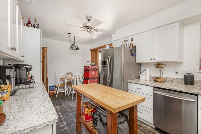kitchen featuring a ceiling fan, white cabinetry, light stone counters, a sink, and appliances with stainless steel finishes