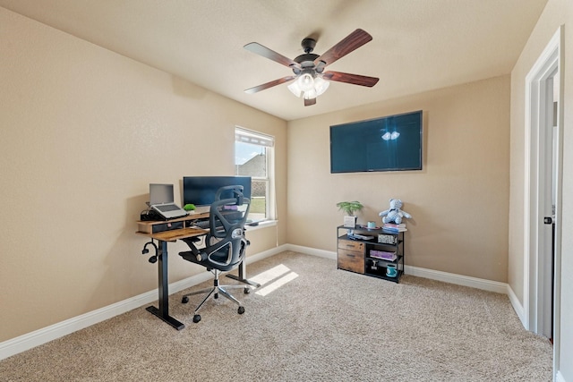 carpeted home office with a ceiling fan and baseboards