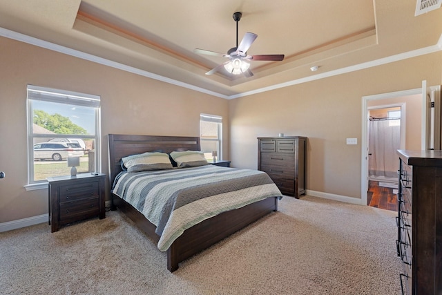 bedroom with visible vents, a tray ceiling, carpet flooring, and multiple windows
