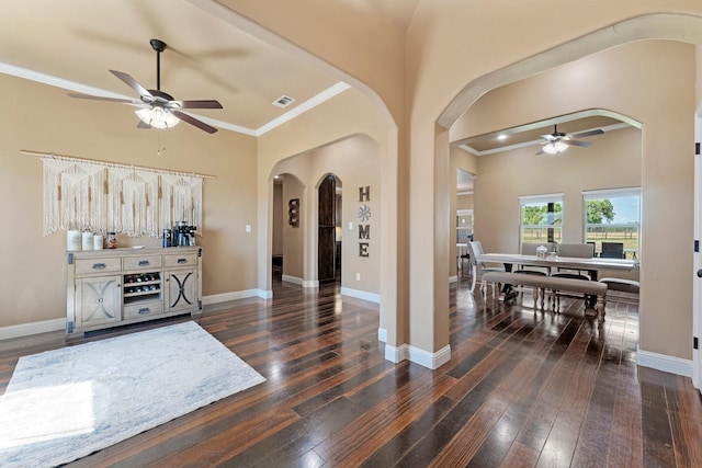 foyer entrance with ceiling fan, arched walkways, wood-type flooring, ornamental molding, and visible vents