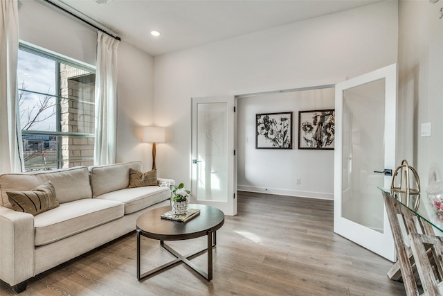living room featuring baseboards, wood finished floors, and recessed lighting
