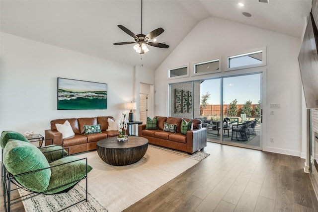 living room featuring baseboards, wood finished floors, high vaulted ceiling, and ceiling fan
