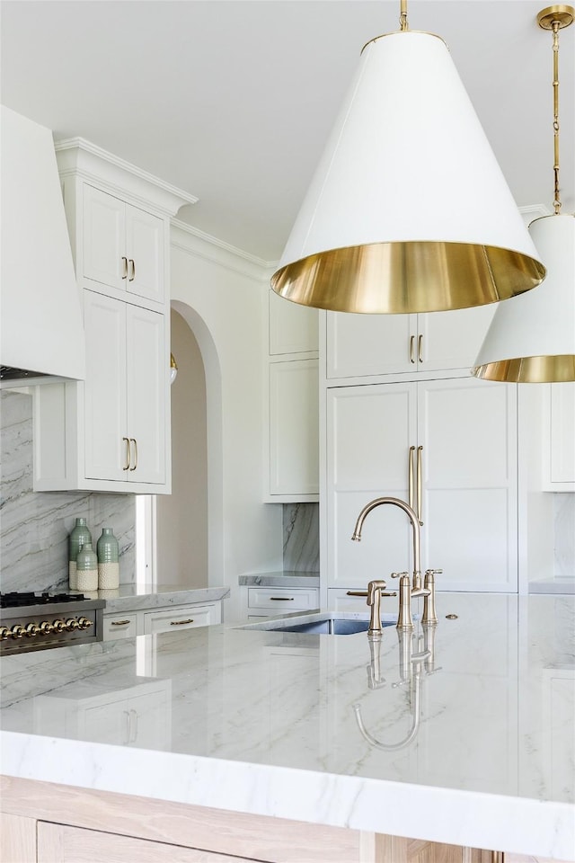 7206 Northaven Rd, Dallas, TX 75230 - kitchen with light stone countertops, decorative backsplash, island exhaust hood, and a sink