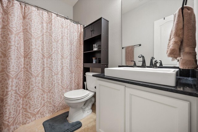 bathroom with a shower with curtain, tile patterned floors, vanity, and toilet
