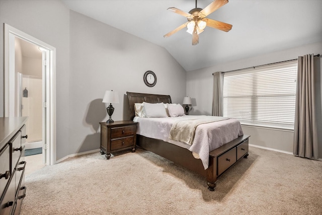 bedroom featuring baseboards, lofted ceiling, ensuite bathroom, and light carpet