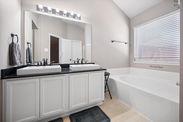 bathroom with a bath, vaulted ceiling, a sink, and double vanity