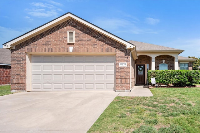 ranch-style house with brick siding, driveway, a front lawn, and a garage
