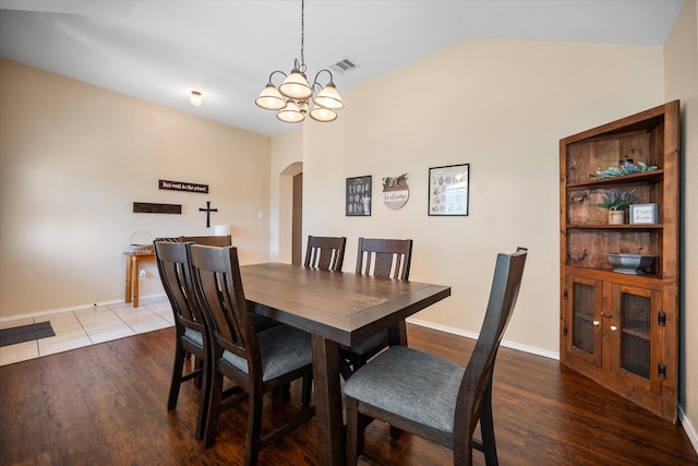 dining space featuring arched walkways, wood finished floors, visible vents, and a notable chandelier