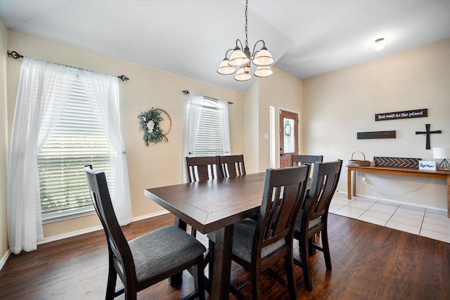 dining area featuring a chandelier, wood finished floors, and baseboards