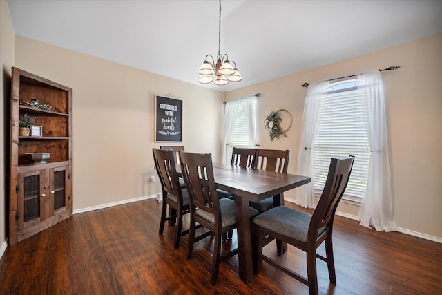 dining space featuring dark wood finished floors, baseboards, and a notable chandelier