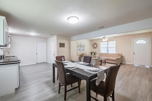 dining room featuring ceiling fan, baseboards, wood finished floors, and visible vents