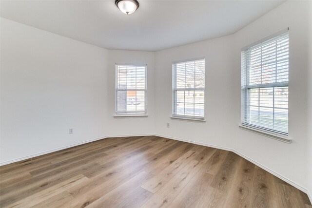 spare room with wood finished floors and baseboards