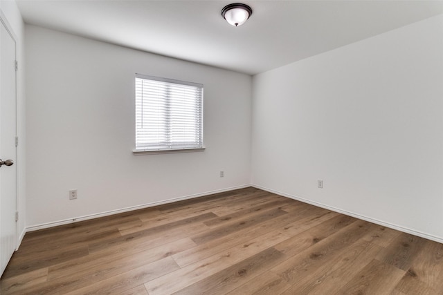 empty room featuring baseboards and wood finished floors