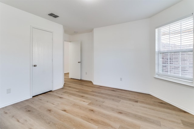 unfurnished bedroom with light wood-type flooring, baseboards, and visible vents