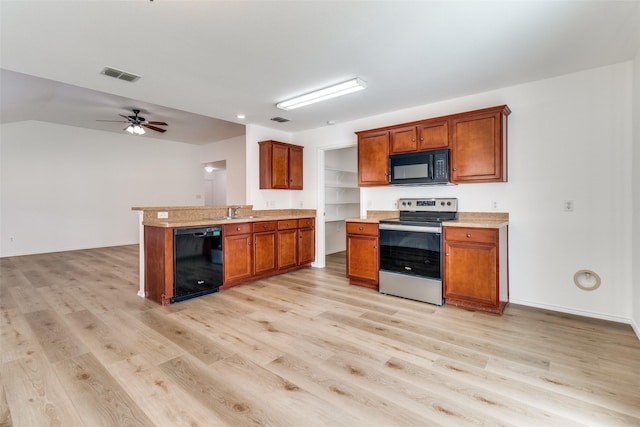 kitchen featuring light wood-type flooring, visible vents, brown cabinets, and black appliances