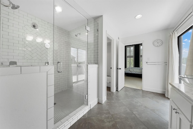 bathroom featuring recessed lighting, vanity, baseboards, a stall shower, and ensuite bathroom