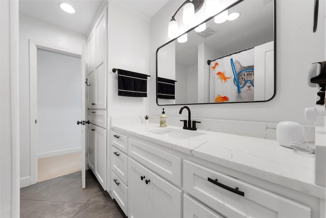 bathroom with baseboards, vanity, tile patterned floors, and recessed lighting