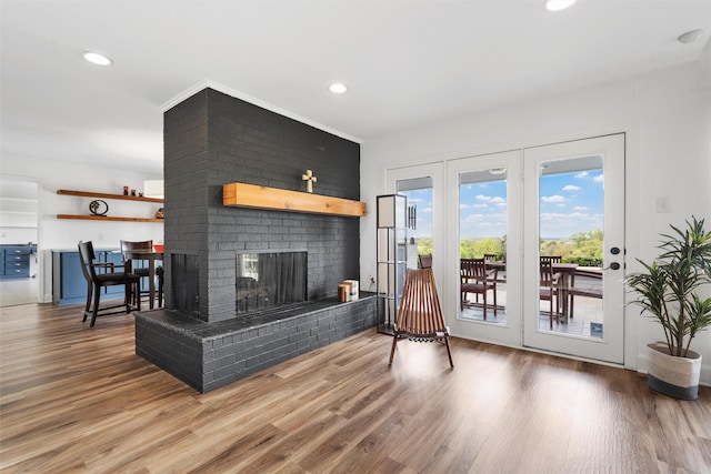 living room featuring a fireplace, wood finished floors, and recessed lighting