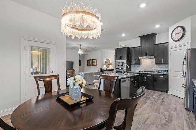 dining area featuring recessed lighting, light wood-style flooring, a toaster, and ceiling fan with notable chandelier