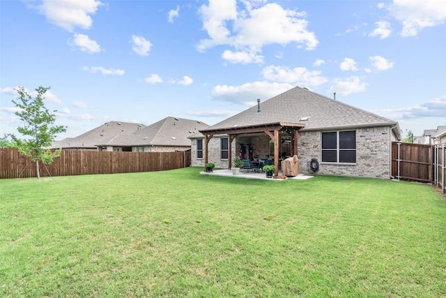 back of house with a fenced backyard, brick siding, a patio area, and a lawn