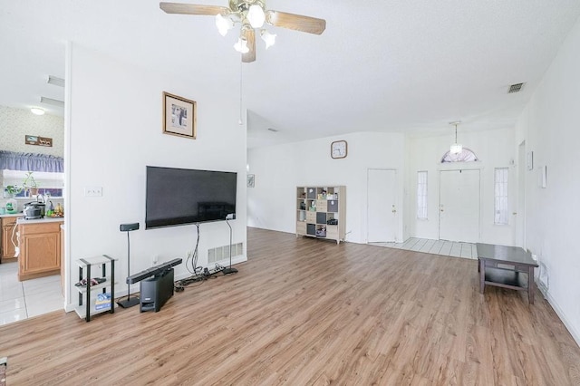 living room featuring light wood-style flooring, visible vents, and a ceiling fan