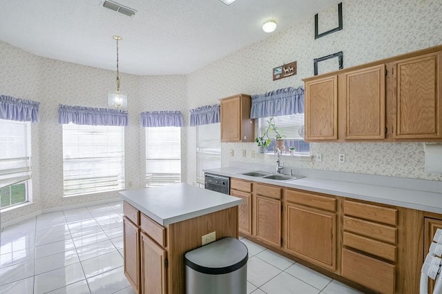 kitchen featuring wallpapered walls, visible vents, light tile patterned floors, and a sink