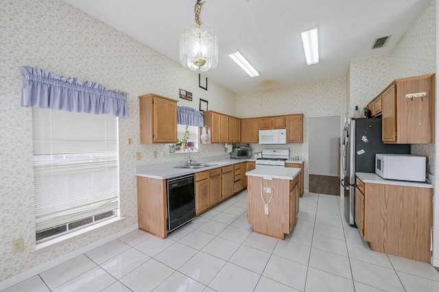 kitchen with wallpapered walls, light countertops, a sink, white appliances, and a center island
