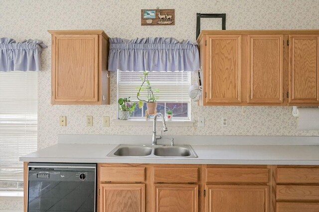 kitchen featuring wallpapered walls, dishwasher, light countertops, and a sink