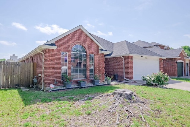 ranch-style house with fence, a shingled roof, a front lawn, brick siding, and a garage