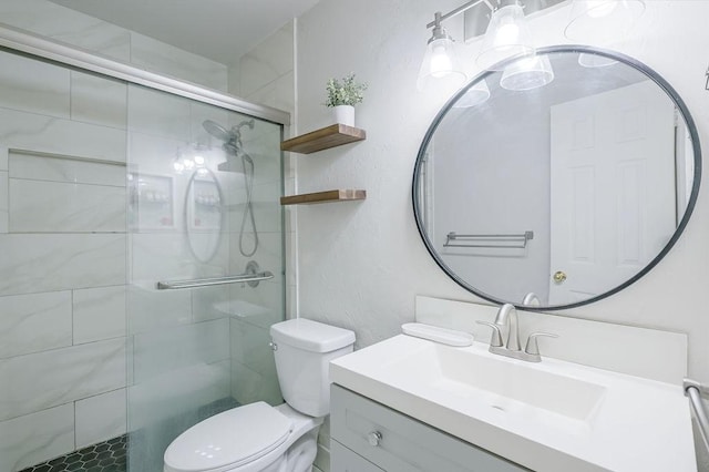 full bathroom featuring vanity, a shower stall, and toilet