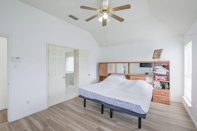 bedroom featuring lofted ceiling, light wood-type flooring, and multiple windows