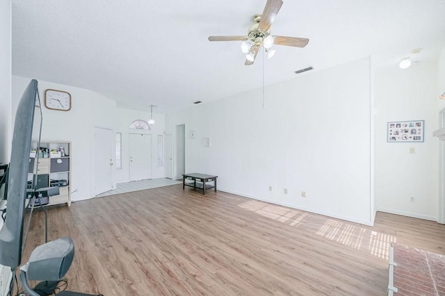 unfurnished living room with baseboards, a ceiling fan, and wood finished floors