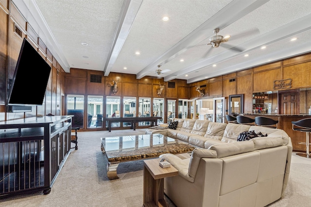 living room featuring light carpet, wooden walls, and beam ceiling