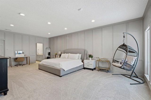 bedroom with recessed lighting, a textured ceiling, a decorative wall, and light colored carpet