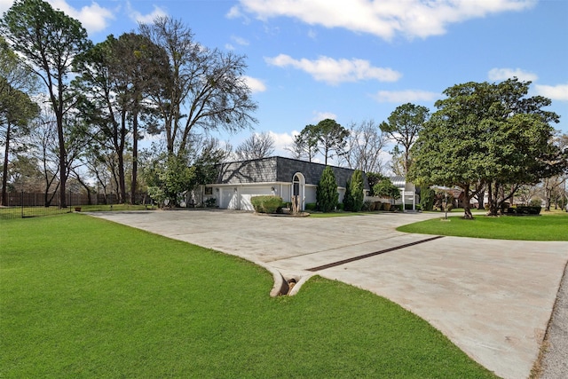 view of front of house featuring mansard roof, a front lawn, and concrete driveway