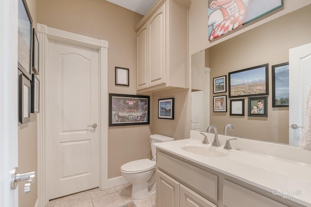 bathroom featuring toilet, vanity, tile patterned floors, and baseboards