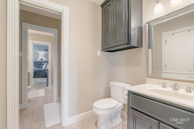 bathroom with tile patterned flooring, vanity, toilet, and baseboards