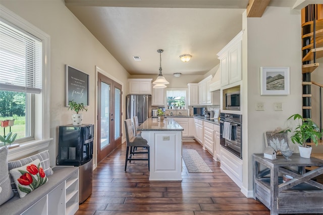 13043 W County Road 4182, Henderson, TX 75654 - kitchen with light stone counters, stainless steel appliances, white cabinetry, a breakfast bar area, and dark wood-style flooring